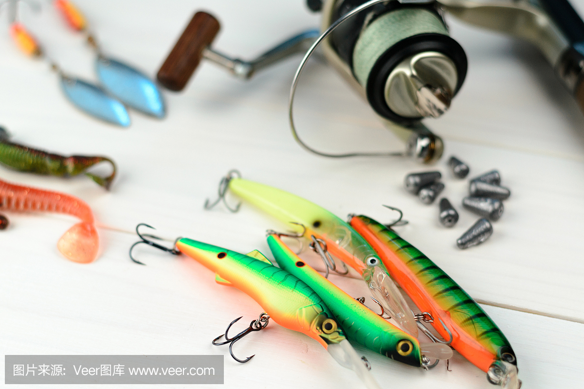 釣竿與卷軸,勺子魚餌,釣具和擺動在盒子里捕捉或捕魚捕食魚在白色復古的木制背景